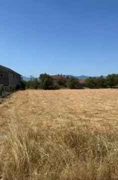 Prostrana parcela sa suvom travom pod vedrim nebom. - image 2