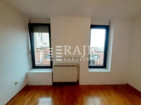 Empty room with two windows, parquet flooring, and a radiator. - image 4