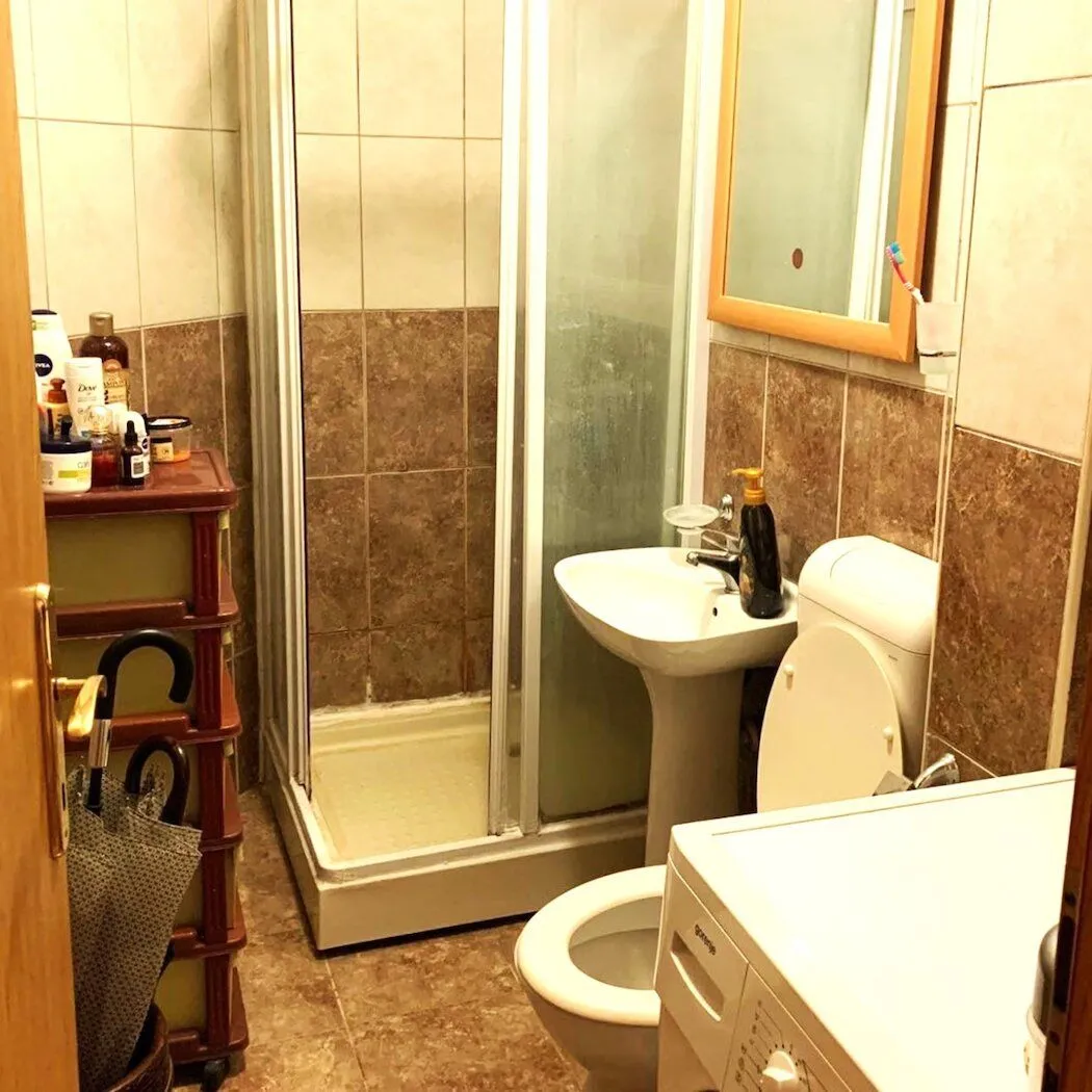 Manje kupatilo sa tuš kabinom, umivaonikom, WC šoljom i veš mašinom.