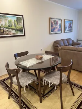 Dining table with chairs in the living room area. - image 9
