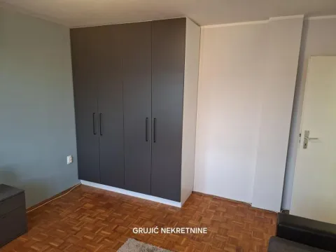 Spavaća soba sa velikim ugradnim garderoberom i drvenim parketom. - image 12