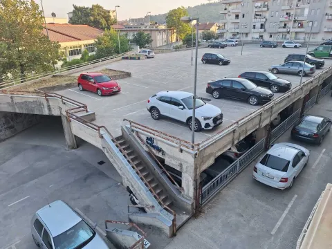 Pogled na parking prostor i prilaz zgradi sa parkiranim automobilima. - image 9