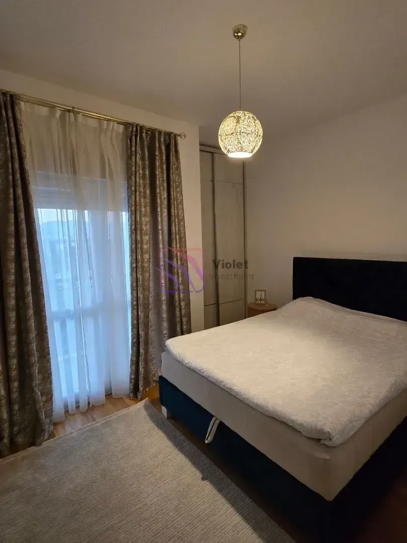Bedroom with a double bed, wardrobe, and a window with curtains.