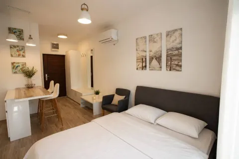 Furnished bedroom with a double bed, dining table, and chairs. - image 2