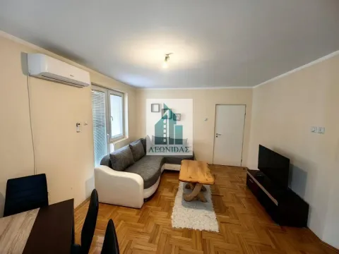 Living room with a sofa, coffee table, TV and air conditioning unit. - image 4