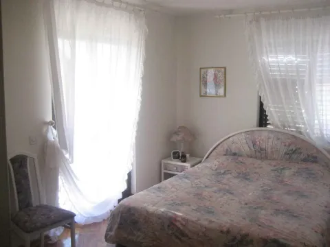 Svijetla spavaća soba sa velikim krevetom i bijelim zavjesama. - image 3
