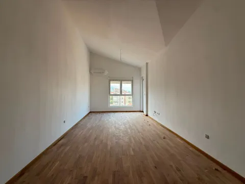 Prazna soba sa parketom i kosim plafonom. - image 2