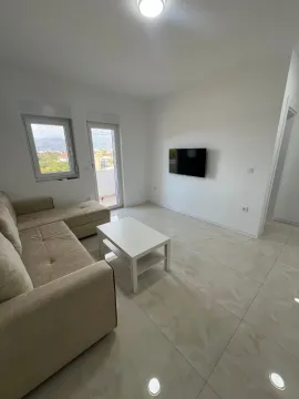 Bright living room with a sofa set, coffee table, and wall-mounted television. - image 3