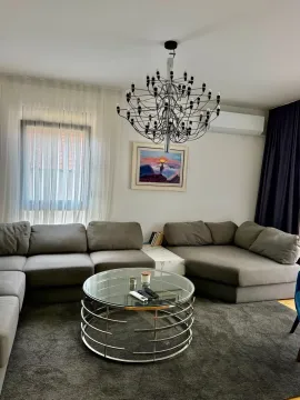 Dnevna soba sa velikom ugaonom garniturom, okruglim stočićem i lusterom. - image 2