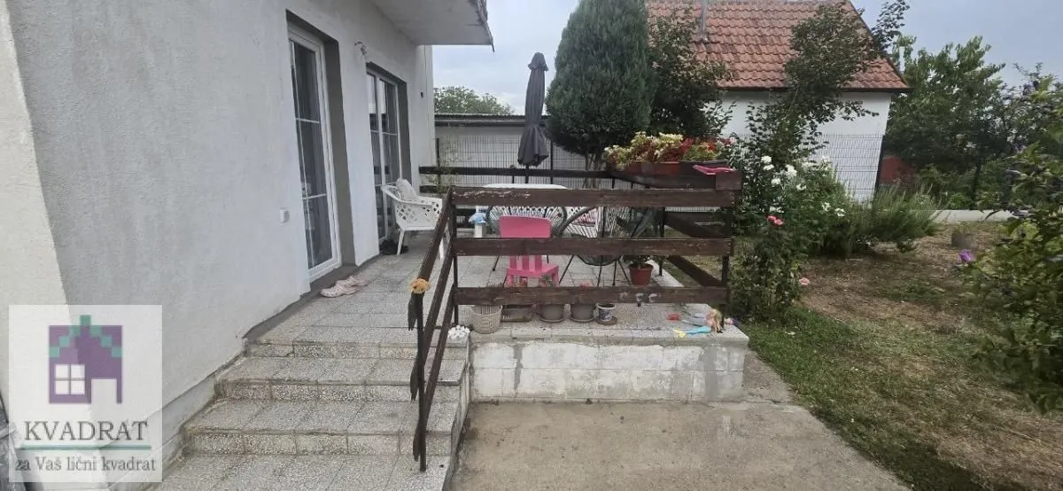 Natkrivena terasa sa drvenom ogradom i stepeništem koje vodi u dvorište.
