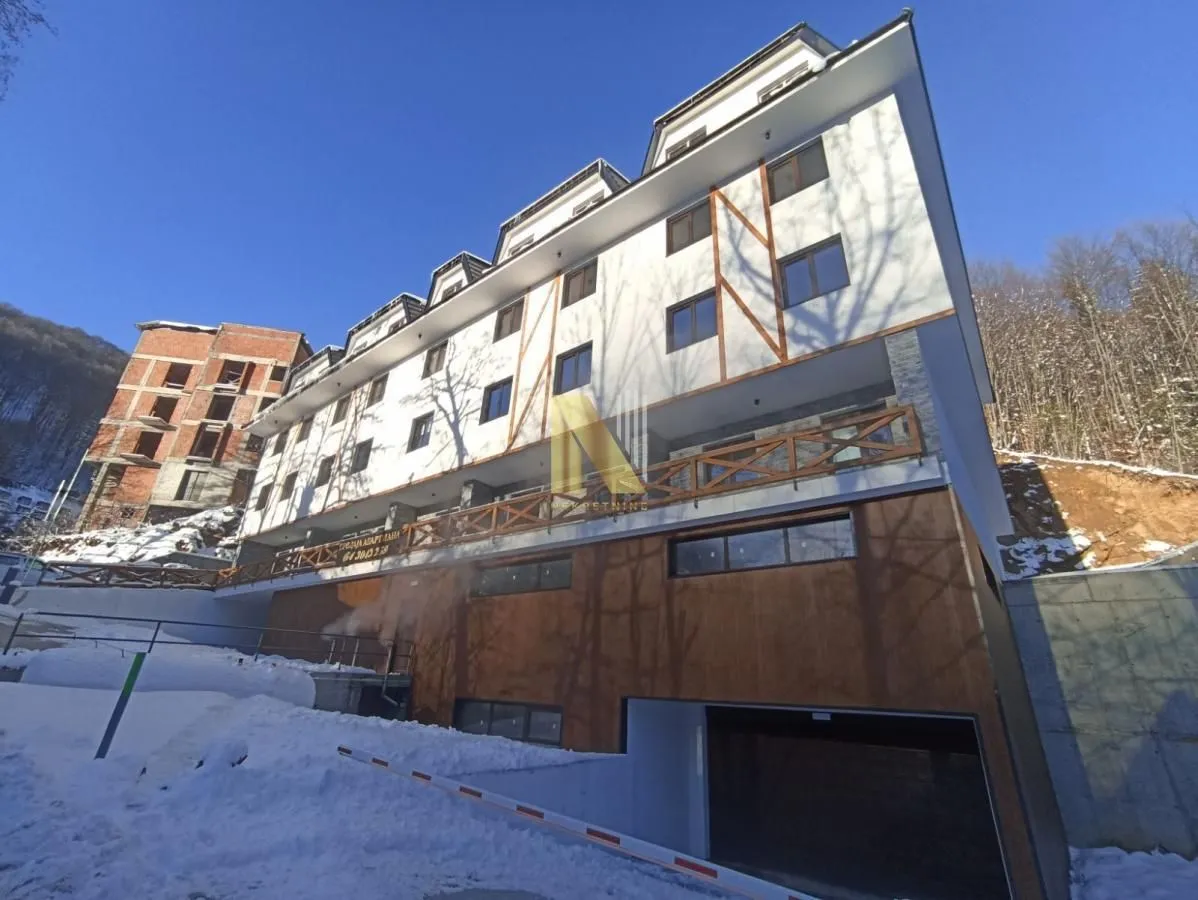 Pogled na spoljašnjost moderne stambene zgrade tokom zimskog perioda.