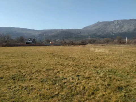 Pogled na prostranu livadu i brda u pozadini. - image 4