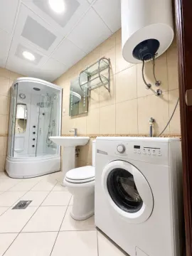 Kupatilo opremljeno tuš kabinom, umivaonikom, toaletom i veš mašinom. - image 5
