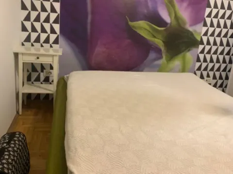 Bedroom with a double bed and decorative wallpaper on the wall. - image 3