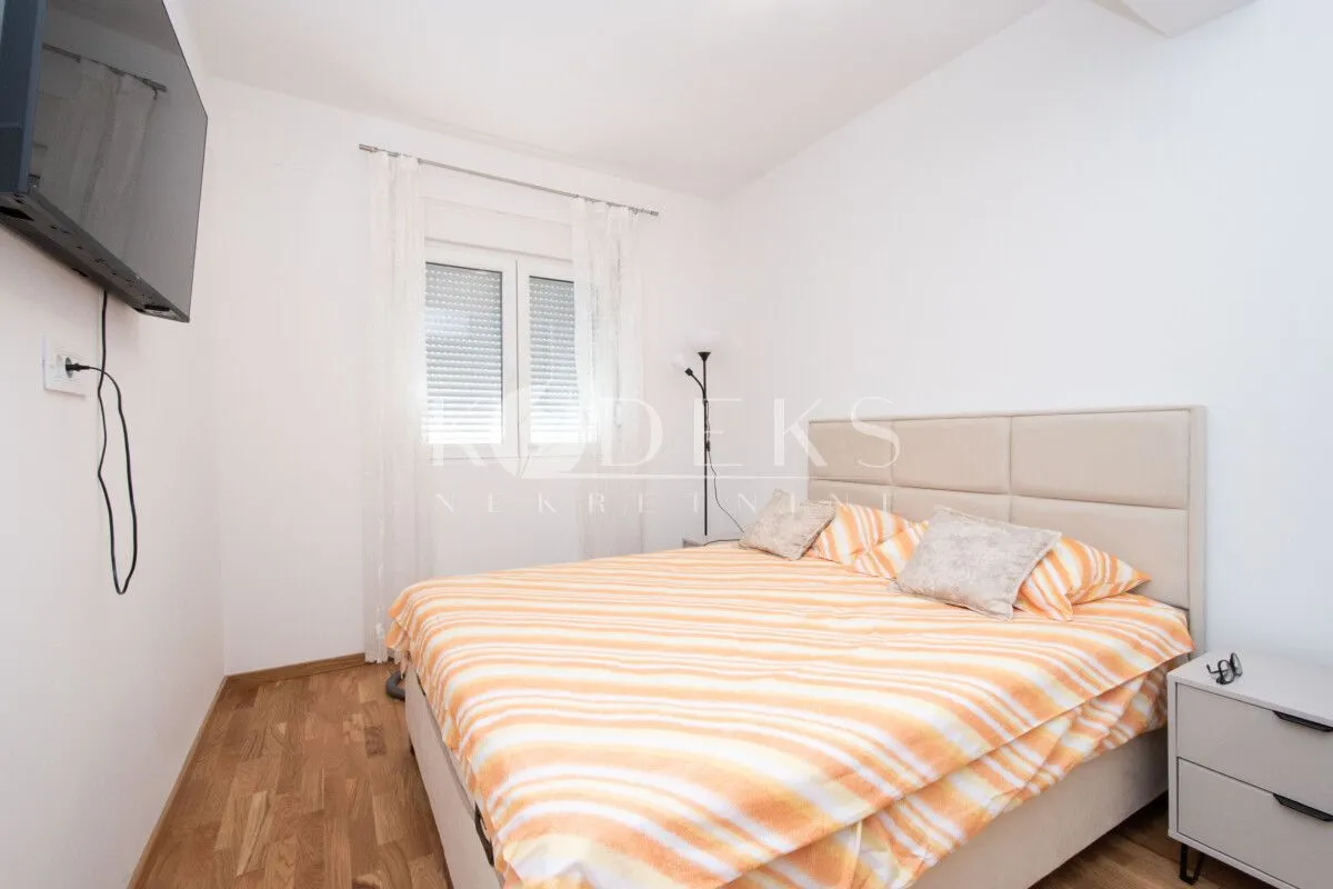 Bedroom with a double bed, bedside table, and a wall-mounted TV.