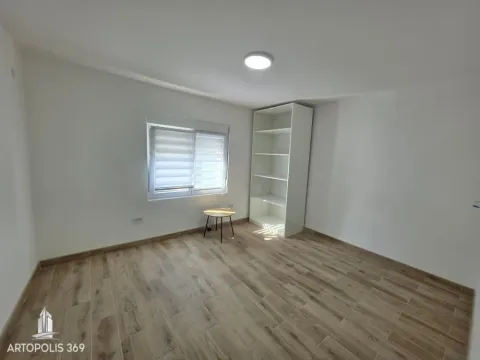 Empty room with white walls, wooden flooring, a window, and a white shelving unit. - image 8