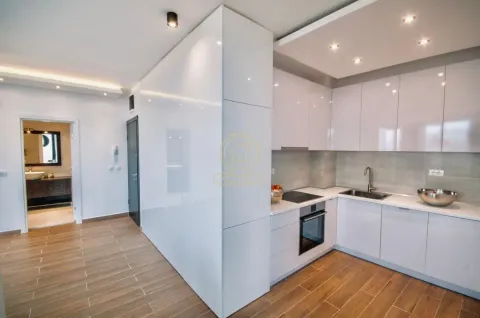 Modern white kitchen with built-in appliances and wooden flooring. - image 4