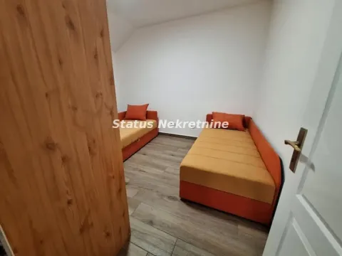 Manja spavaća soba sa dva kreveta i laminatom na podu. - image 6
