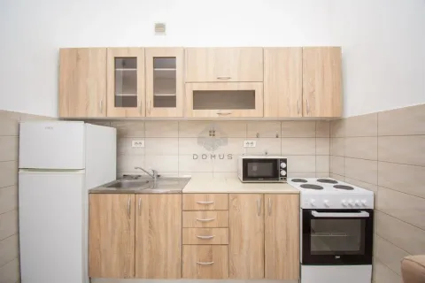 Manja kuhinja sa drvenim elementima, frižiderom, šporetom i mikrotalasnom pećnicom. - image 9