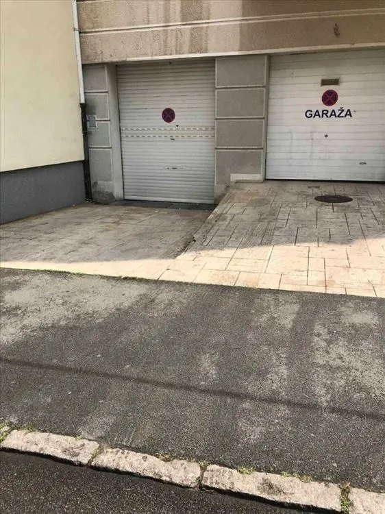 Entrance to the garage with roller shutter doors in front of the building.