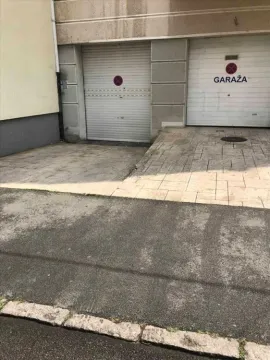 Entrance to the garage with roller shutter doors in front of the building. - image 2