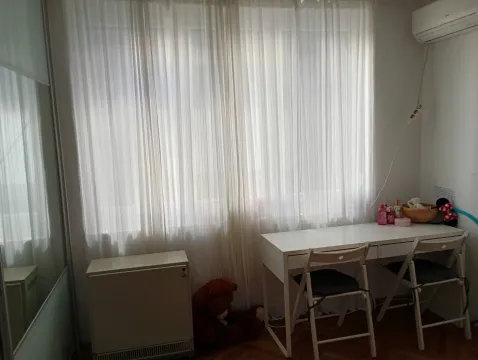 Spavaća soba sa radnim stolom i belim zavesama na prozoru. - image 10