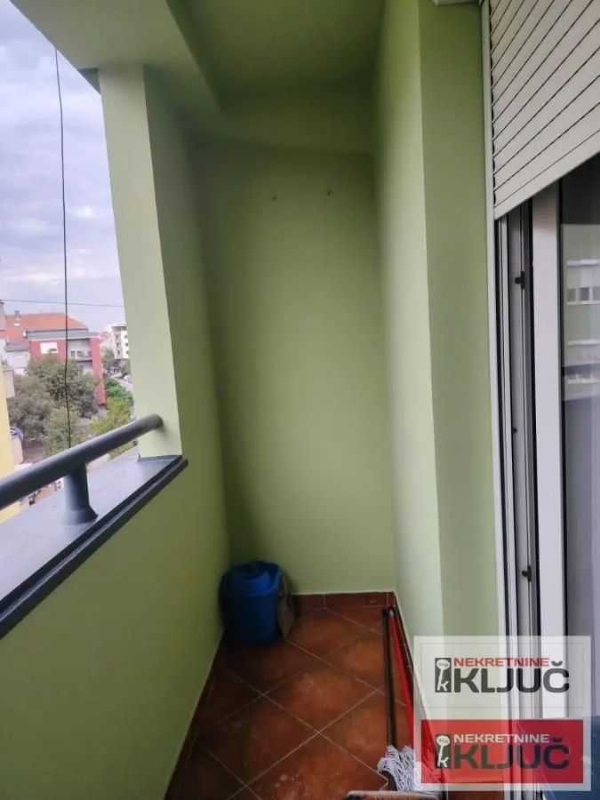 Manji natkriveni balkon sa pločicama na podu i pogledom na okolinu.