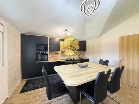 Modern kitchen with dining area and black cabinetry. - image 8