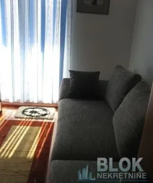 Living room with a grey sofa and a curtained window. - image 4