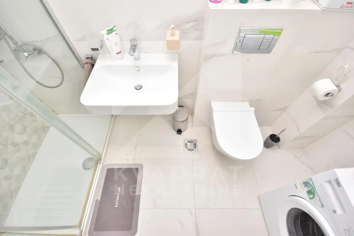 Top-down view of a modern bathroom equipped with a shower cabin, washbasin, and toilet.