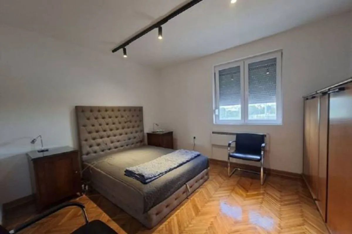 Bedroom with a double bed, bedside tables, and a wooden wardrobe.