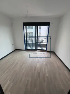 Prazna neopremljena soba sa drvenim podom i balkonskim vratima. - image 2