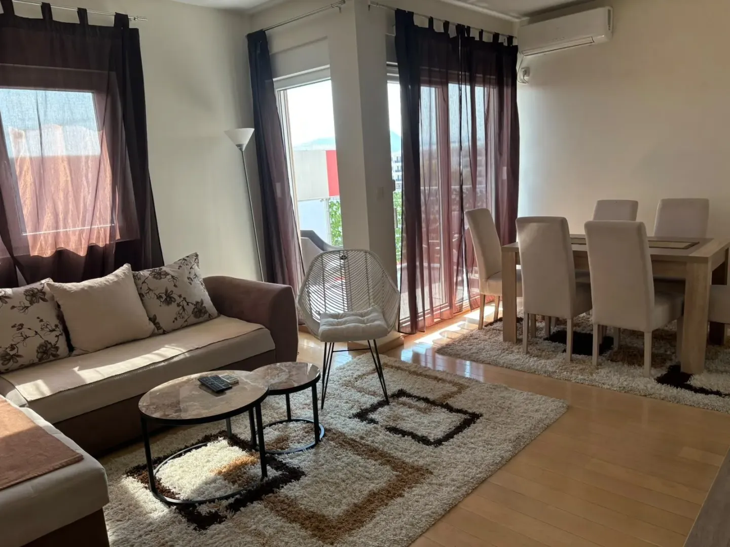 Living room with a sofa, coffee tables, and a dining table with chairs.