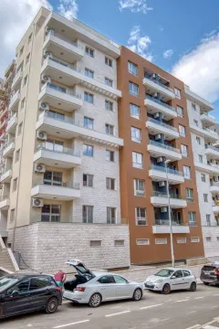 Exterior view of a modern residential building with balconies and parking. - image 13