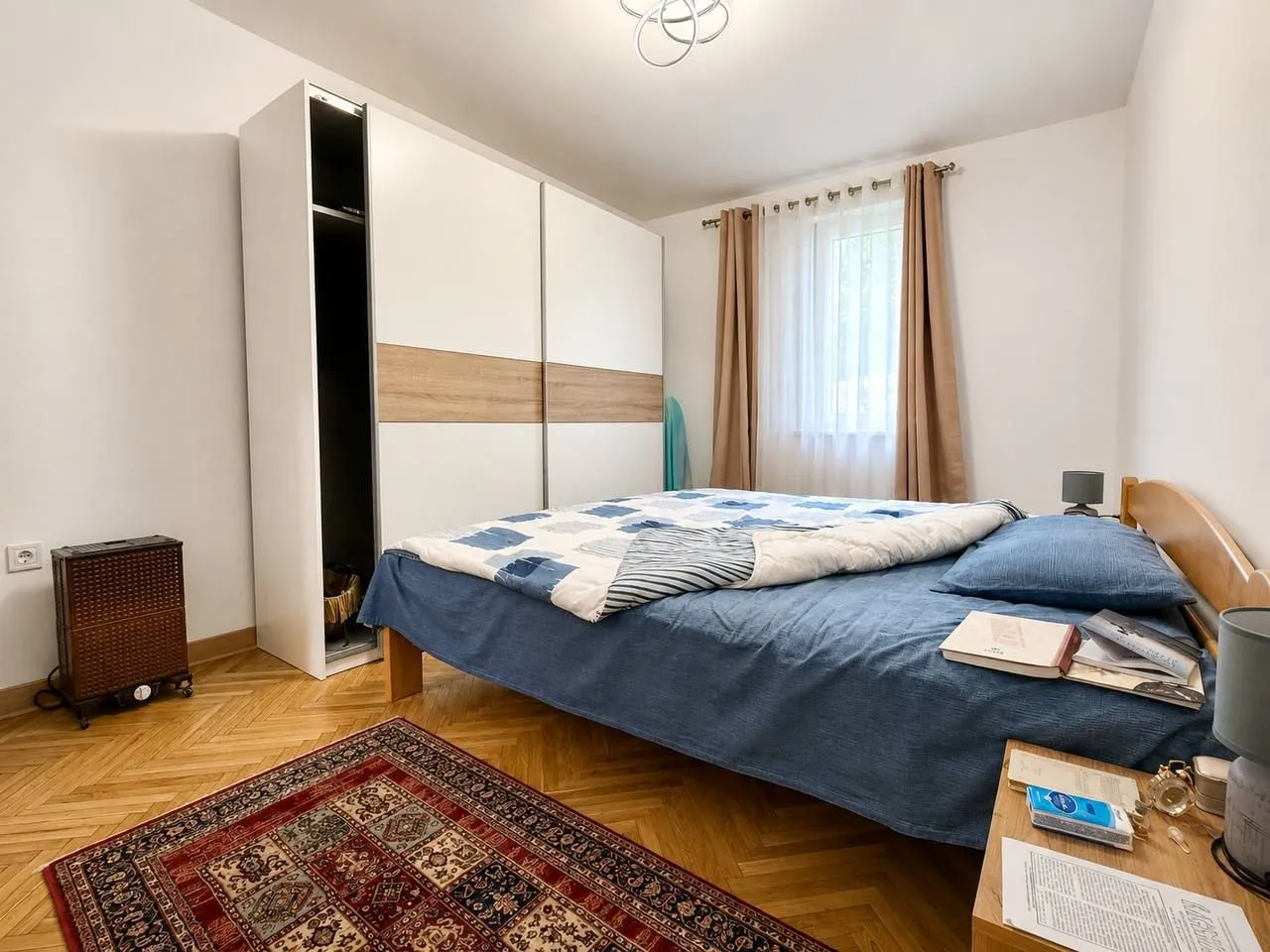 Furnished bedroom with a large wardrobe and a double bed.