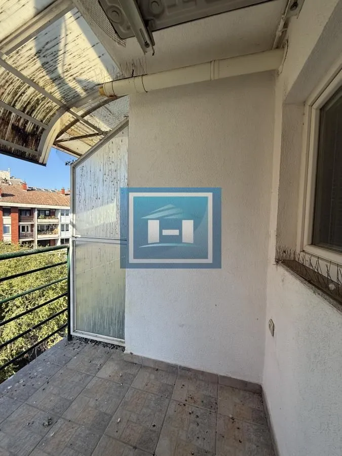 Manji natkriveni balkon sa pločicama i metalnom ogradom.