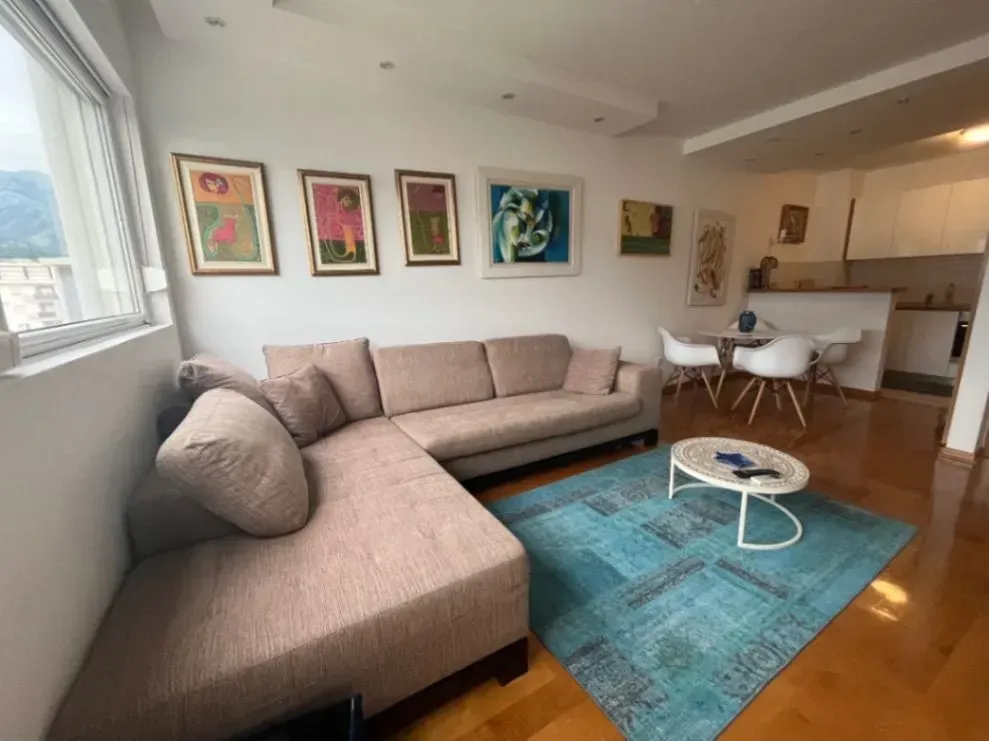 Living room with a sofa, coffee table, and paintings on the wall.