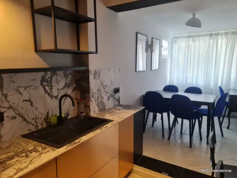 Kitchen with a sink and an open dining area with blue chairs. - image 4