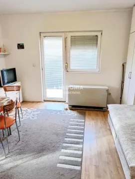 Living room with a bed, dining table, and access to the terrace. - image 9