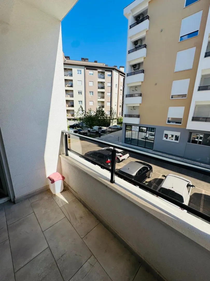 View from the balcony overlooking surrounding buildings and parking.