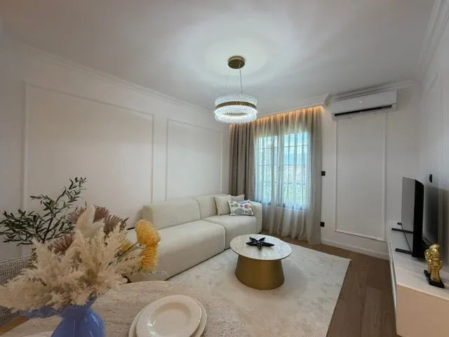 Moderna i svijetla dnevna soba sa garniturom i trpezarijskim stolom.