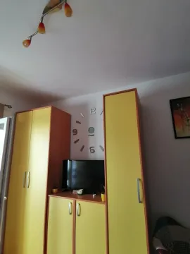 Part of a room featuring yellow wardrobes and a television. - image 9