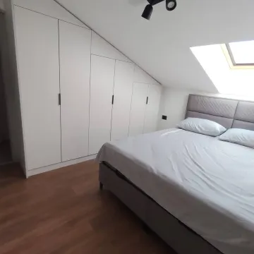 Attic bedroom with a double bed, built-in wardrobe and a skylight. - image 11