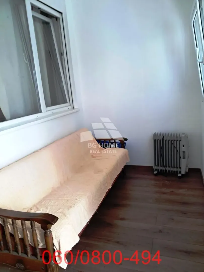 Zastakljena terasa sa kaučem i radijatorom.