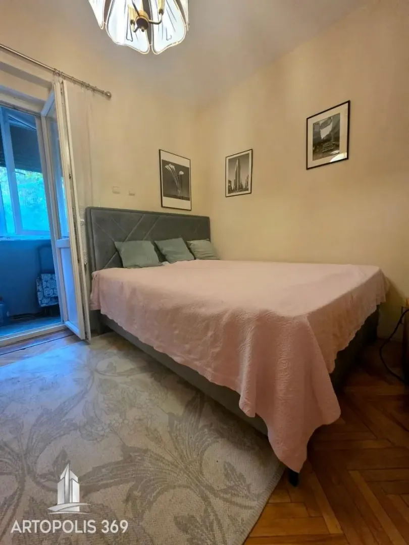 Spavaća soba sa bračnim krevetom i izlazom na balkon.