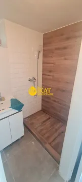 Small bathroom with a walk-in shower and white washbasin. - image 9