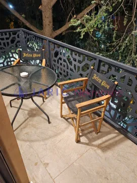 Covered terrace with a table and two chairs. - image 16