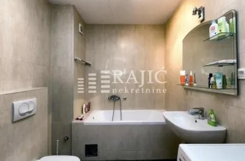 Small bathroom with a bathtub, washbasin, and toilet. - image 6