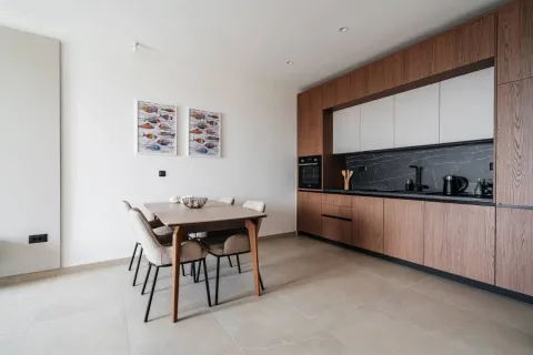 Modern kitchen with wooden elements and a dining table. - image 8