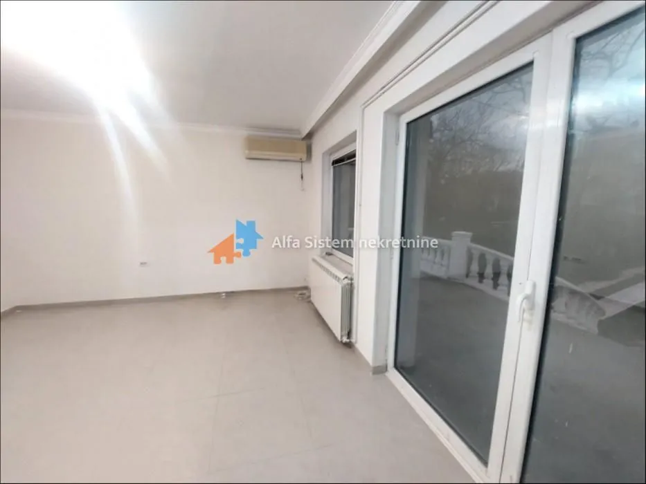 Empty bright room with access to the terrace and an air conditioner.